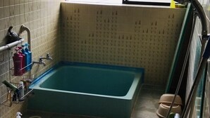 Un bagno con una vasca, un water e una finestra.