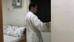 A room with a bed, a window with a curtain, and a wall-mounted air conditioner. - Charlina Rooms for Rent (Panglao)
