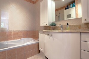 A modern bathroom with a freestanding bathtub, white cabinetry, and a large mirror above the sink. - Modern Family Home 5 min to Beach +Pool +Garage.                                (Antibes)