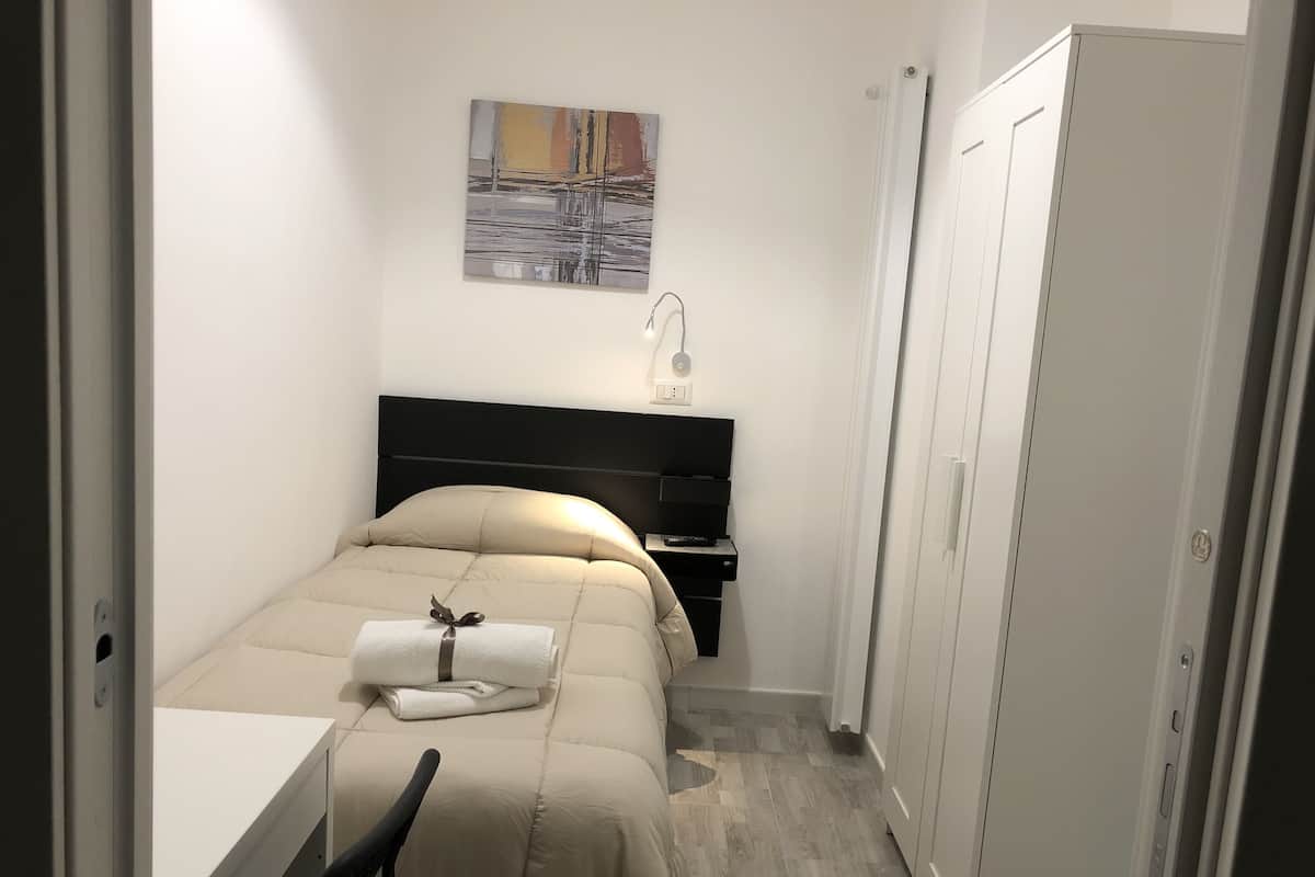 Une chambre d’hôtel avec un lit, une table de chevet, une lampe et un tableau au mur.