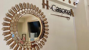 A mirror with a gold frame and a nameplate above it.