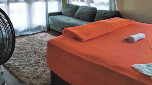 A room with a bed, a sofa, and a fan. - Residencial Rodrigues (Florianópolis)