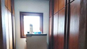A narrow hallway with wooden paneling and a window at the end. - Residencial Rodrigues (Florianópolis)