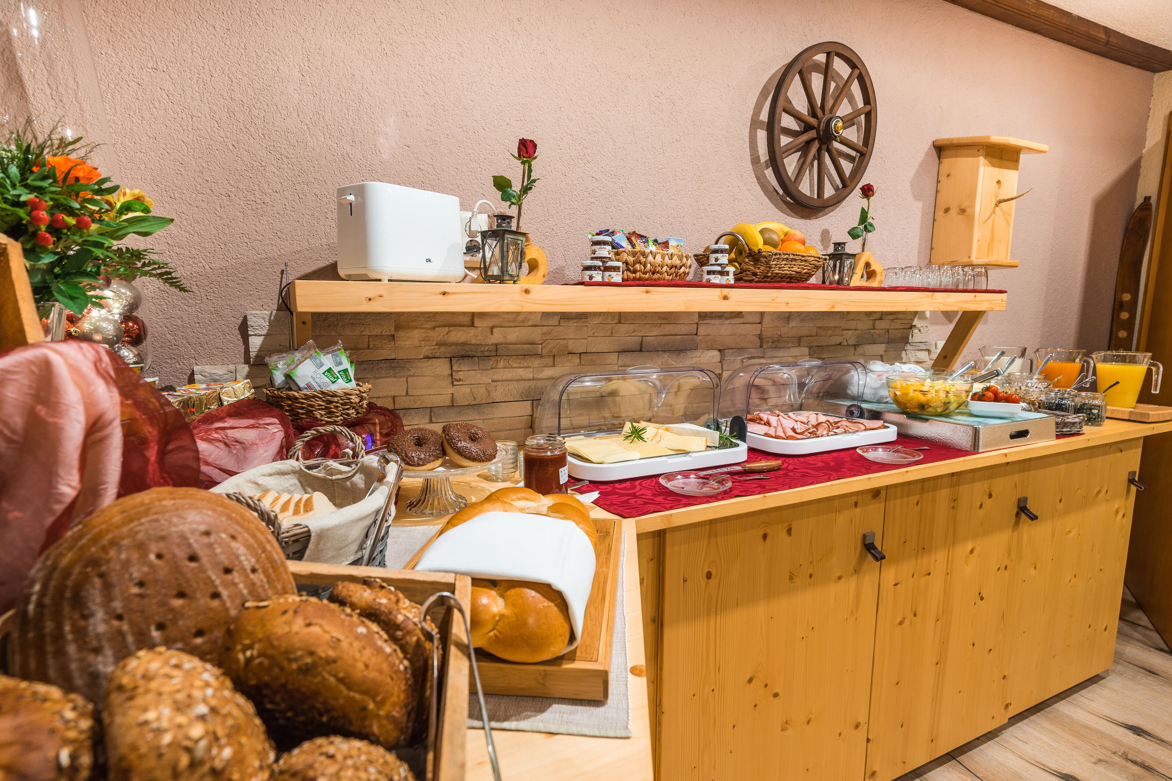 Un ricco buffet della colazione con pane, dolci e bevande di vario tipo.