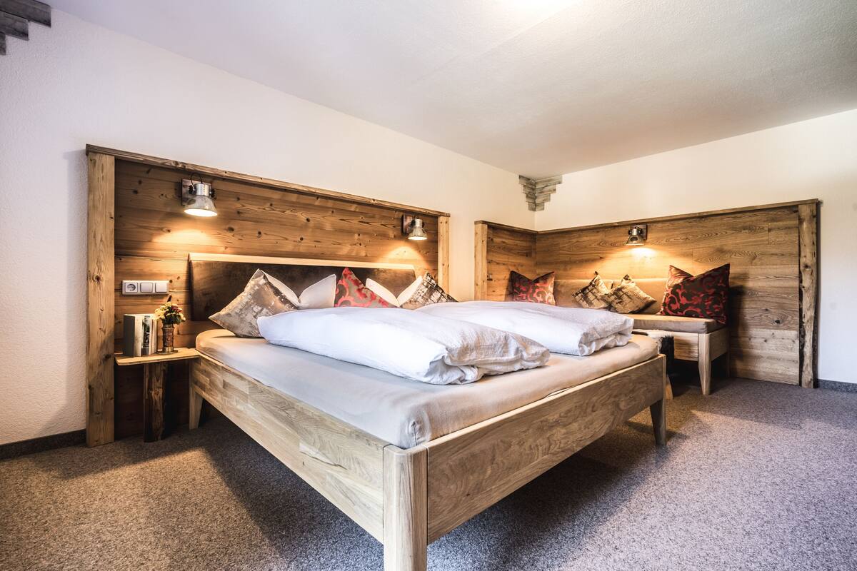 A bedroom with a wooden bed, two bedside tables, and a wooden headboard.