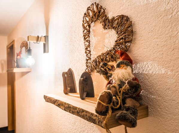 A shelf with a Santa Claus figure, a heart-shaped wreath, and a light fixture. - Haus Stüttler Duchscherer (Schruns)
