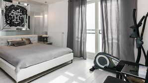 A modern bedroom with a large bed, a treadmill, and a large mirror with a decorative frame. - Apartment Piękna4U 116 m2 (Śródmieście)