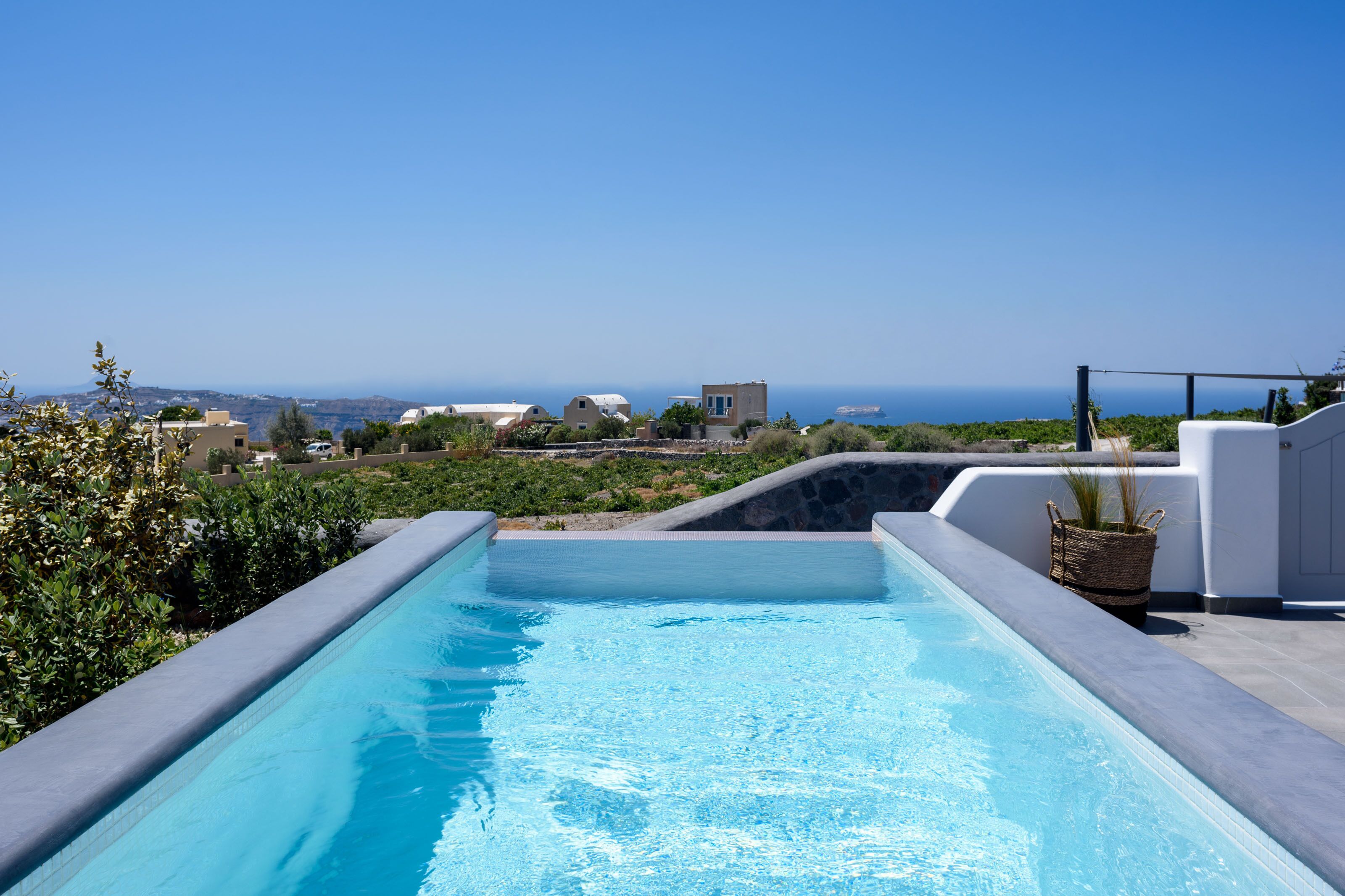 A swimming pool with a view of the sea and surrounding buildings.