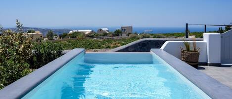 A swimming pool with a view of the sea and surrounding buildings.