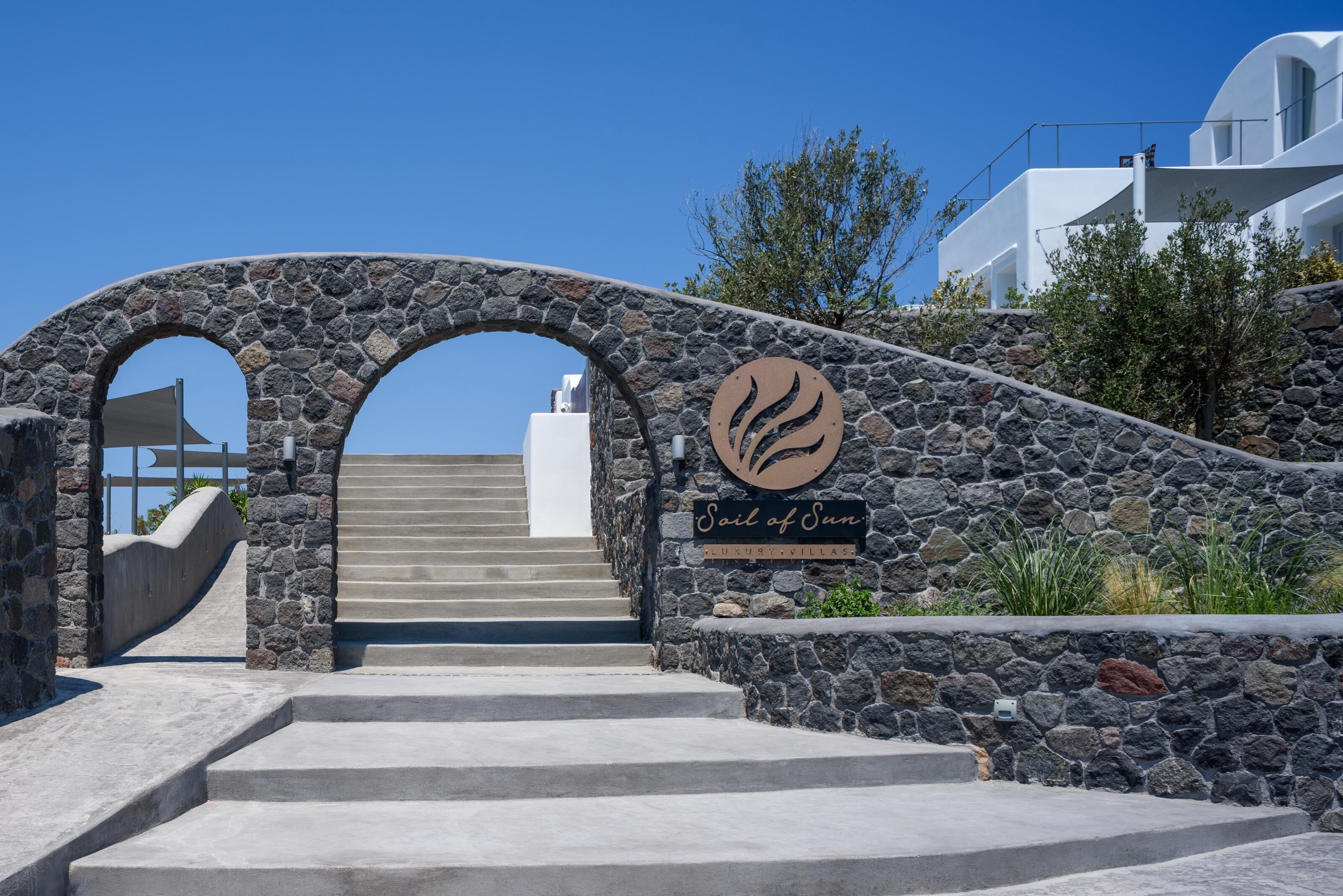 Un arco de piedra que da acceso a una escalera, con un cartel que dice 'Sail of Sun'.