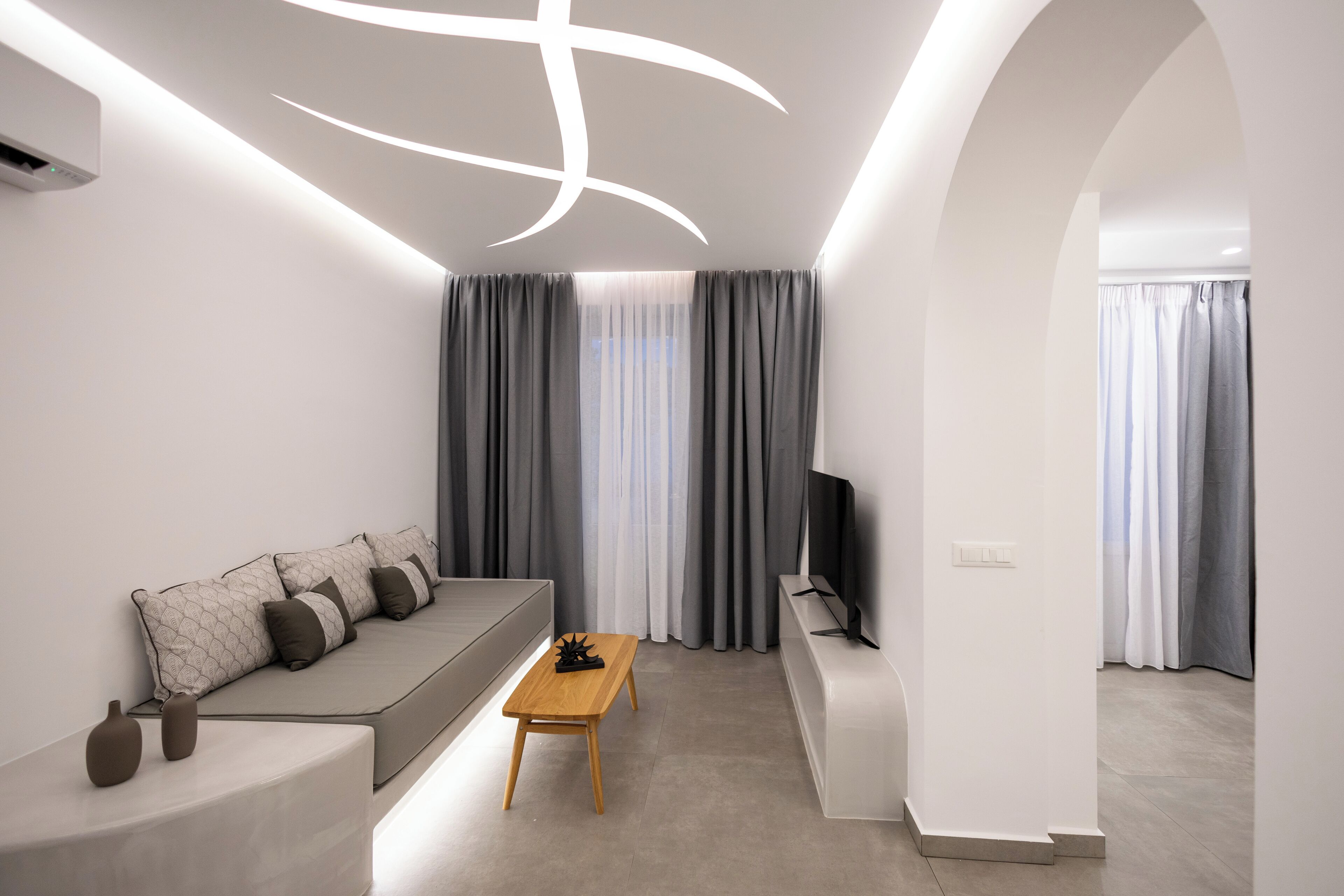 A modern living room with a sofa, a coffee table, and a TV.