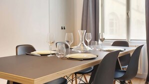 A dining area with a table set for four, including wine glasses and plates.