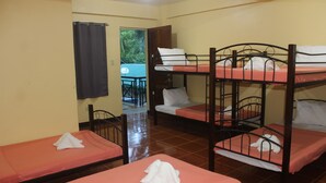 Quarto de dormitório com beliches, uma mesa pequena e uma cadeira.
