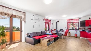 Ein modernes Wohnzimmer mit einer Couch, einem Esstisch und einer Küchenzeile.