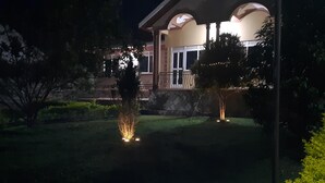 A house with a well-maintained lawn and a small tree in the foreground. - Airport Side Hotel Entebbe (Entebbe)