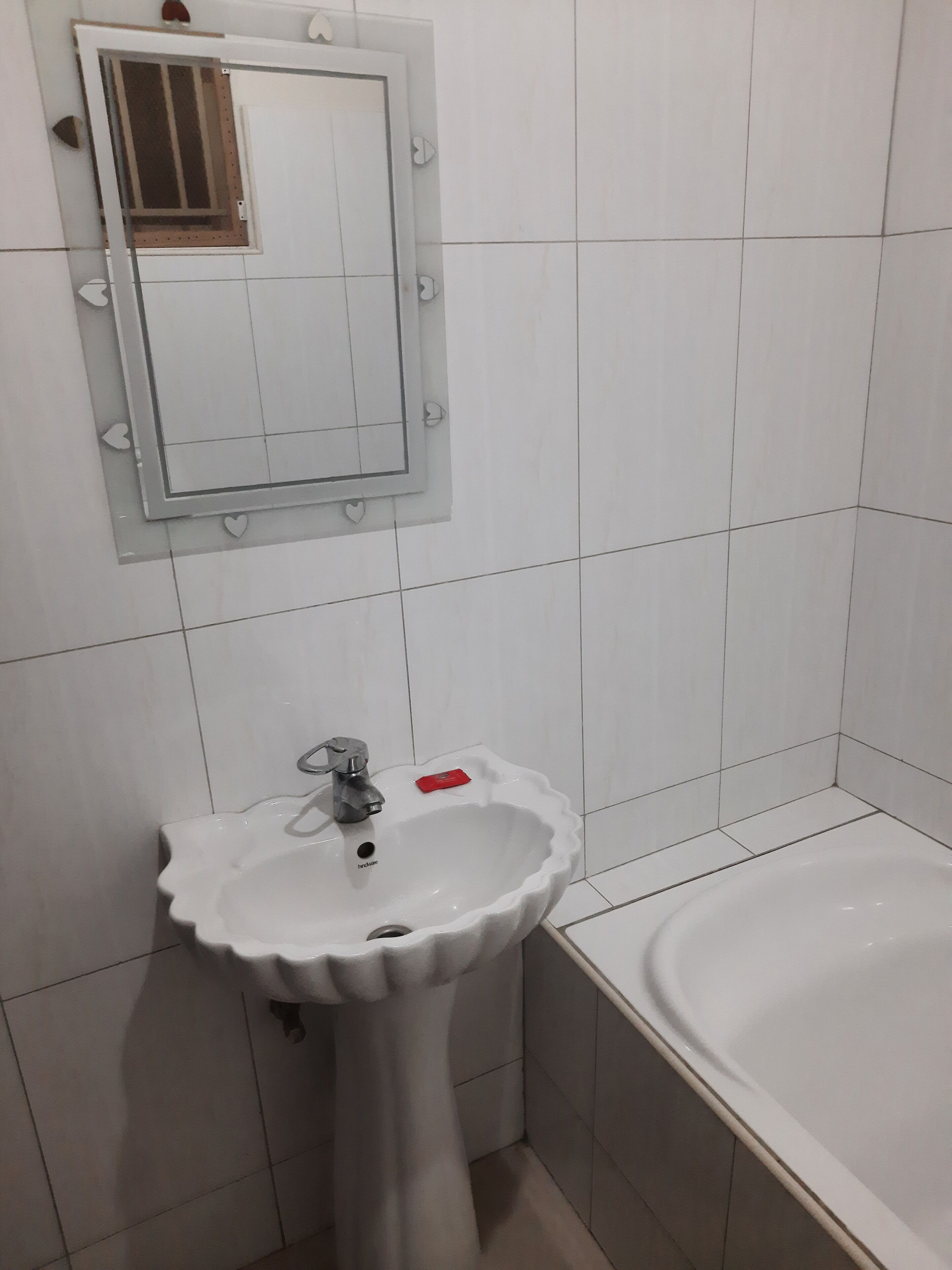 A bathroom with a white sink, a mirror, and a bathtub.