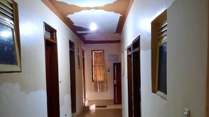 A narrow hallway with tiled flooring, wooden doors, and a ceiling fan. - Airport Side Hotel Entebbe (Entebbe)