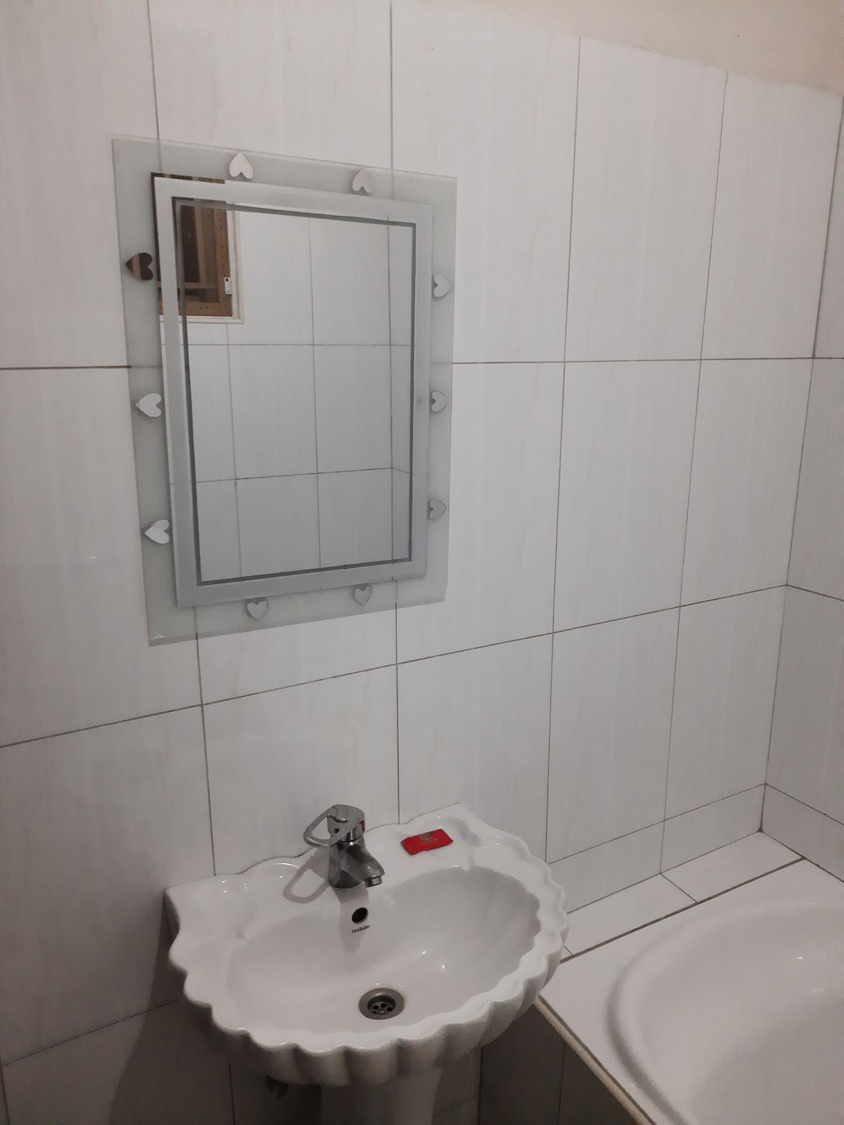 A bathroom with a white sink, a mirror, and a bathtub.