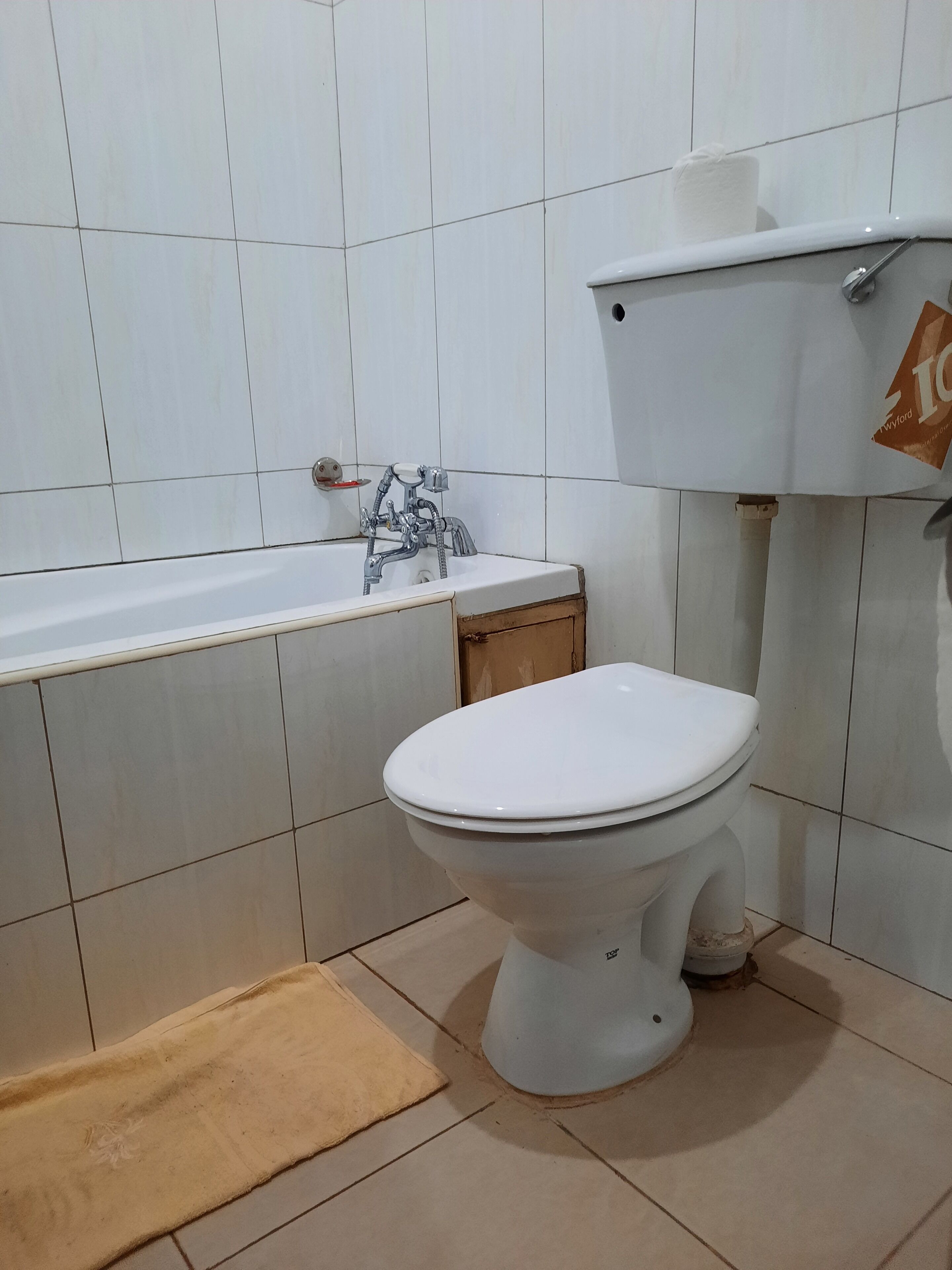 Un baño con inodoro blanco, bañera y lavabo.