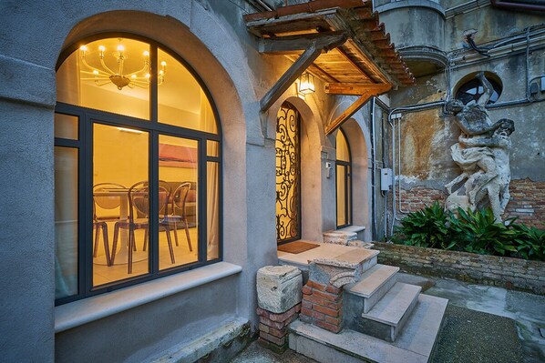 A building with arched windows, a staircase, and a stone sculpture.