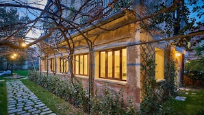 Un bâtiment moderne doté de grandes fenêtres et d’un chemin en pierre menant à l’entrée.