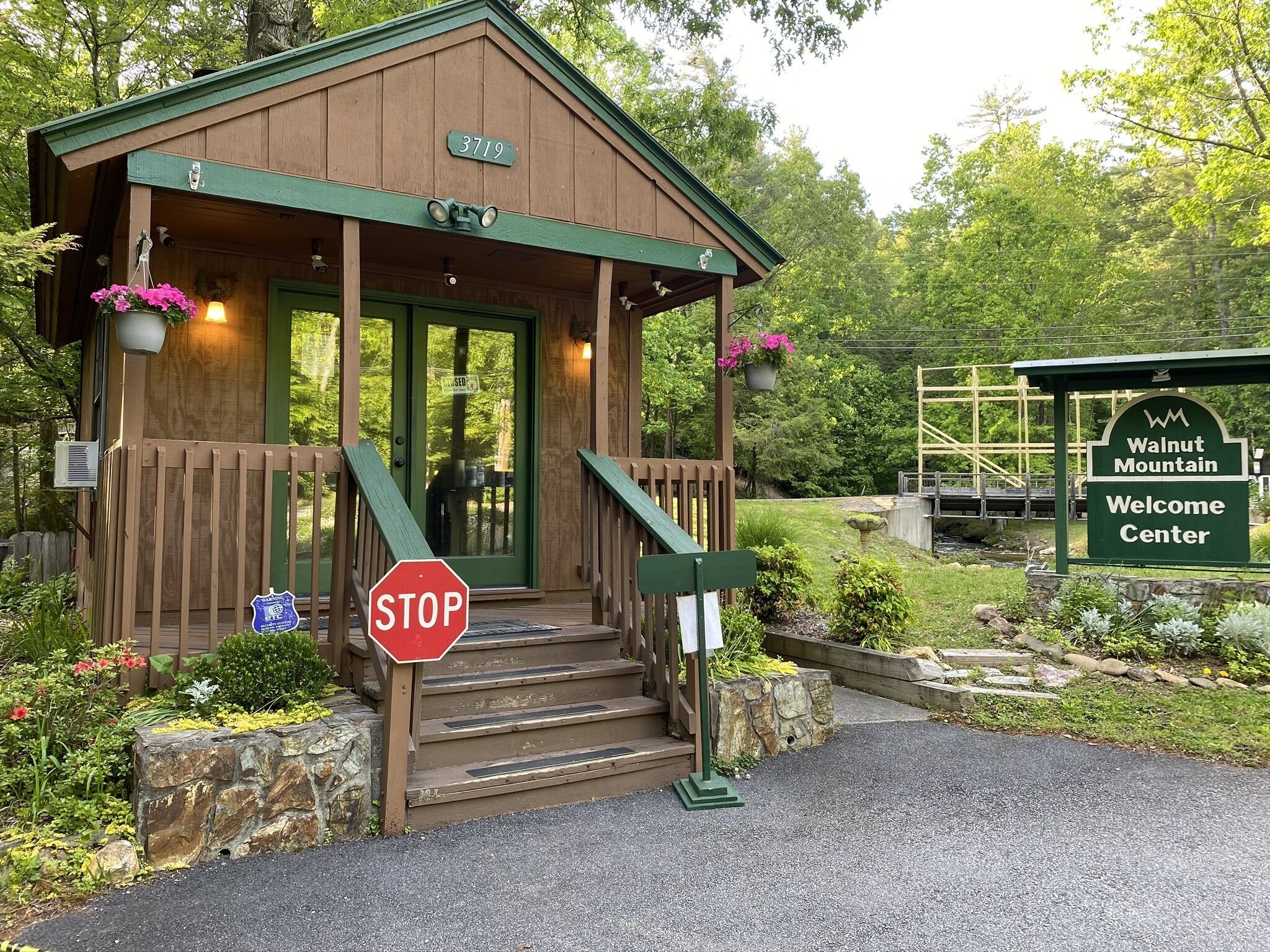 A wooden building with a green door and a stop sign in front.