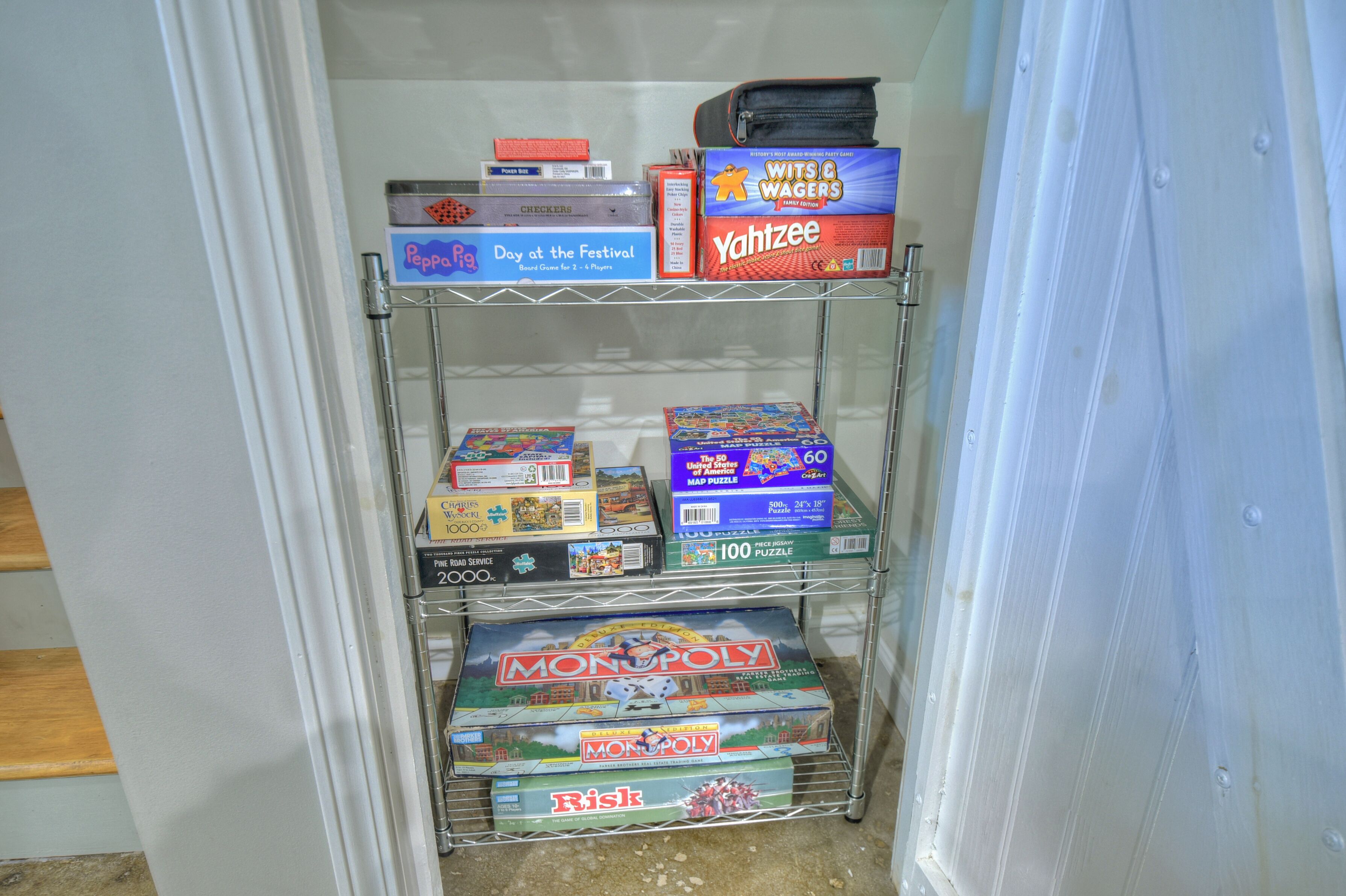 A shelf with board games including Monopoly, Risk, and others.