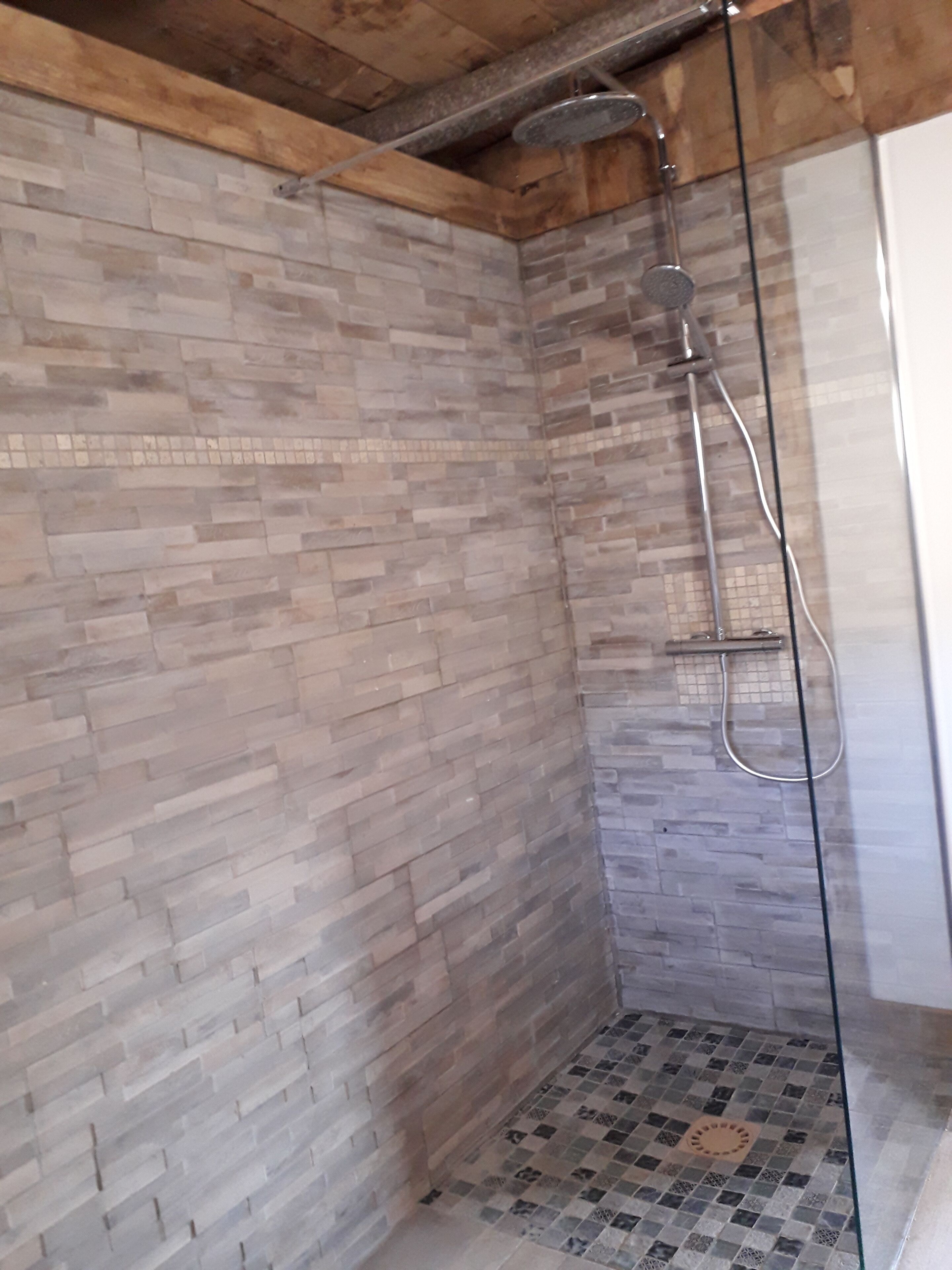 A shower area with a tiled floor and a showerhead.