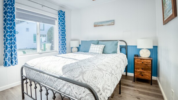 A bedroom with a bed, a nightstand, a ceiling fan, and a window with curtains. - T05 - Dinghy @ Trollers Lodge (Depoe Bay)