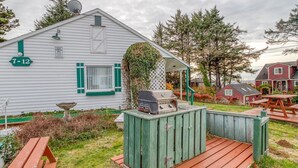A mobile home with a deck and barbecue grill, surrounded by trees and a picnic table. - T11 - Trawler @ Trollers Lodge (Depoe Bay)