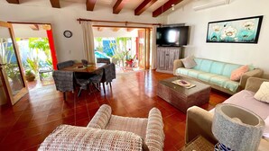 A spacious living area with a dining table, sofas, and a television. - Private home one block to the beach! 2 bedrooms. Premier Zona Dorado location! (Bucerias)