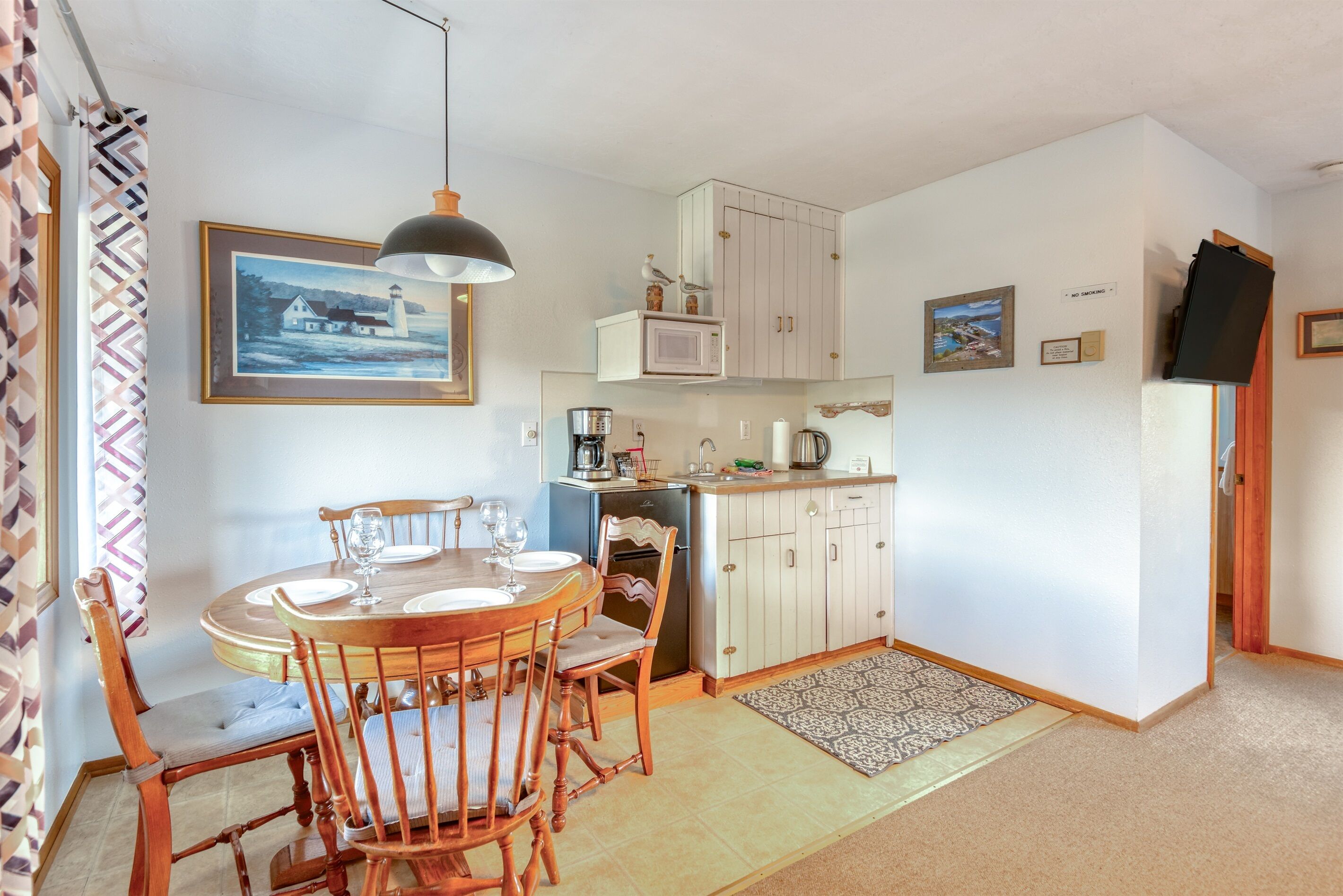 A compact kitchen with white cabinets, a microwave, and a coffee maker.