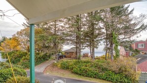 A covered porch with a view of a road, trees, and houses. - T12 - Whaler @ Trollers Lodge (Depoe Bay)