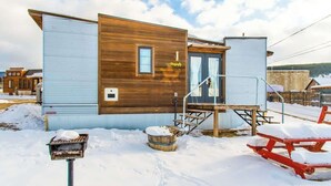 Una cabaña moderna con revestimiento de madera y lateral de metal azul.