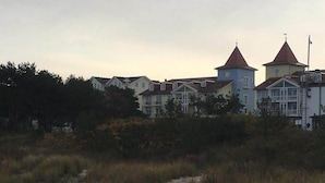 A coastal building with multiple towers and a sandy foreground. - Ground floor apartment Gerbera (Zinnowitz)