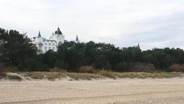 A beach with a large white building in the background. - Ground floor apartment Gerbera (Zinnowitz)