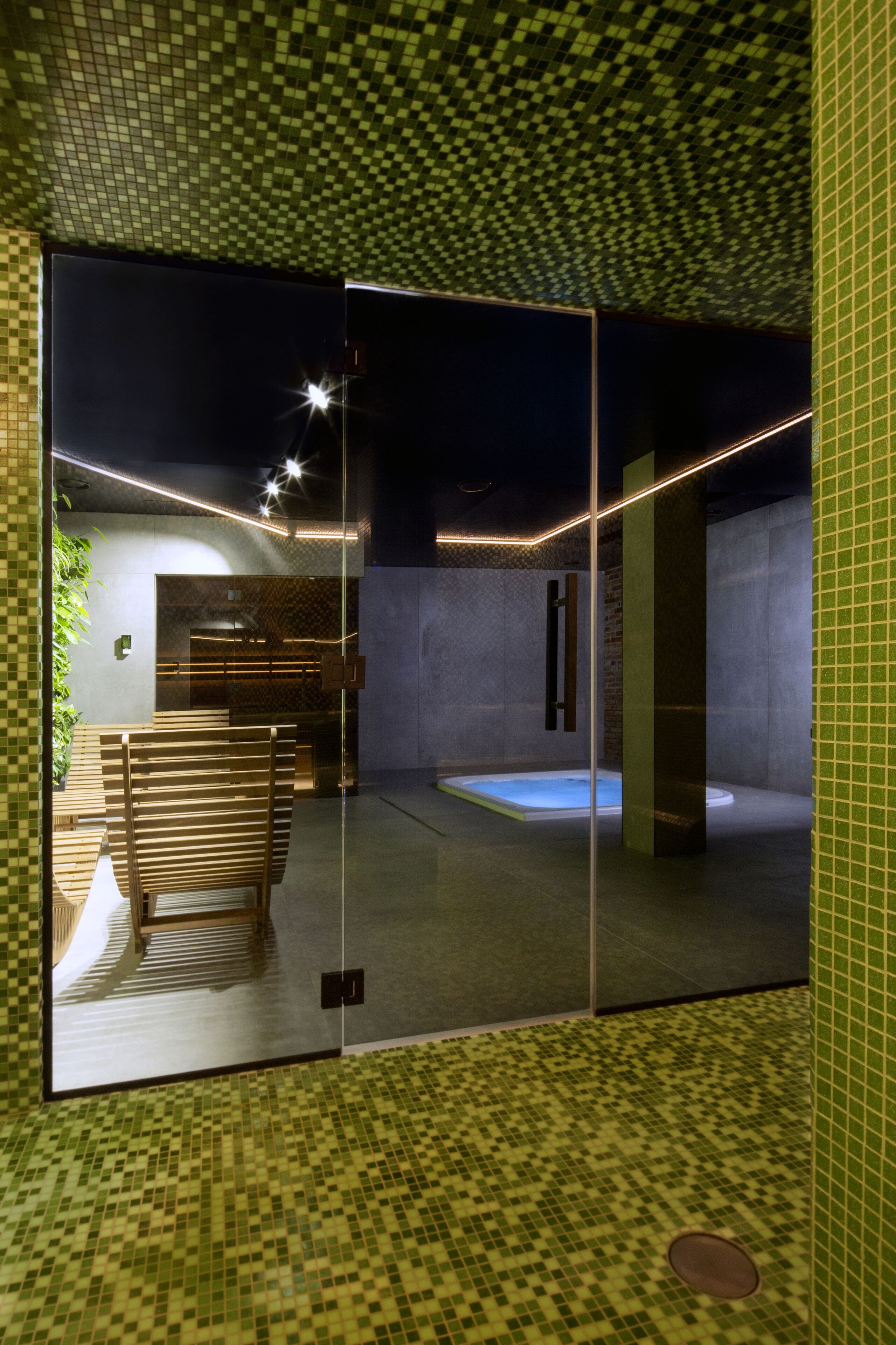 A modern interior with a checkered floor, a glass partition, and a seating area with benches.