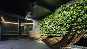 A modern interior with a vertical garden wall, wooden benches, and a staircase. - Green Deer Premium (Zakopane)