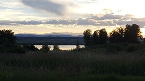 Un paysage comprenant des montagnes, des arbres et une étendue d’eau.