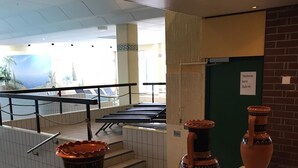 Un sol carrelé sur lequel sont disposés trois grands pots en terre cuite, placés sur des piédestaux.