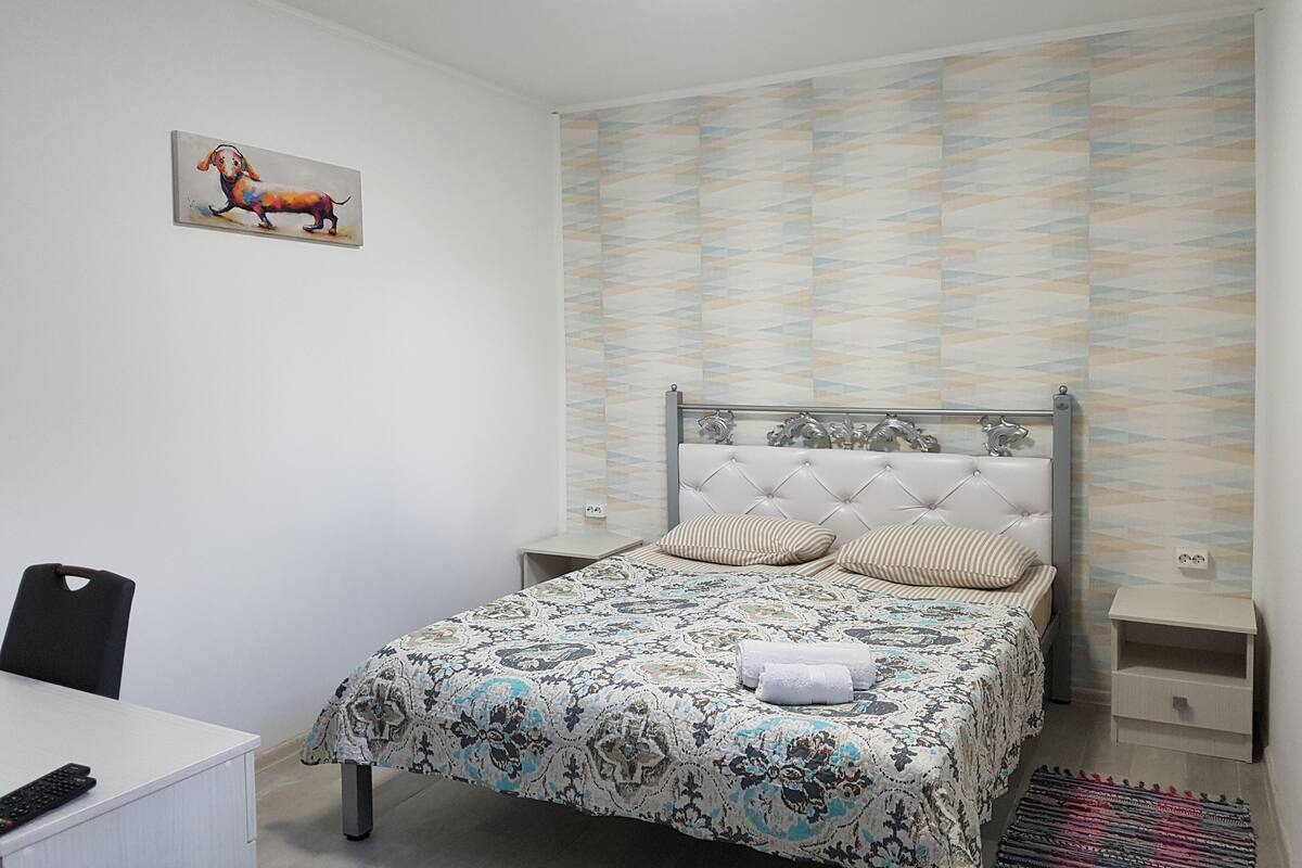 Un dormitorio con cama, escritorio y silla.