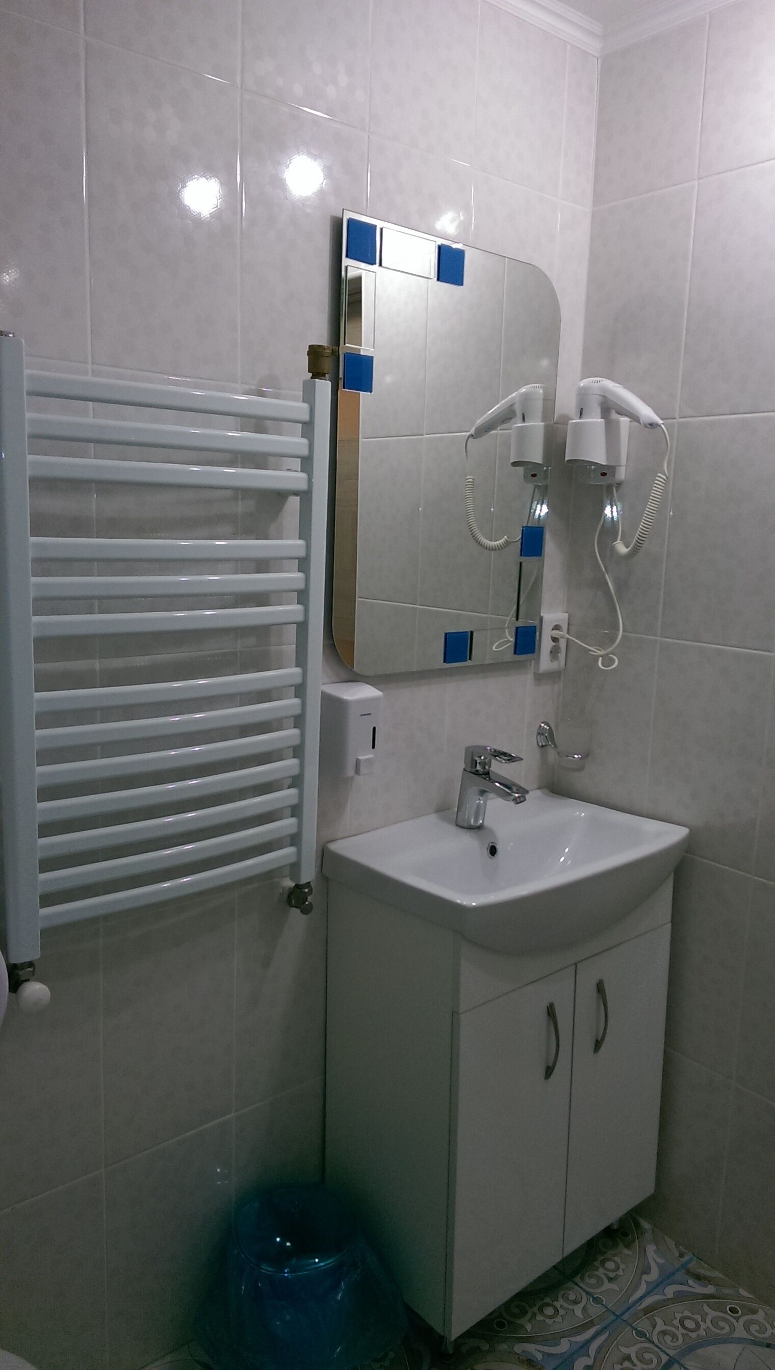 A bathroom with a white sink, a mirror, and a towel rack.