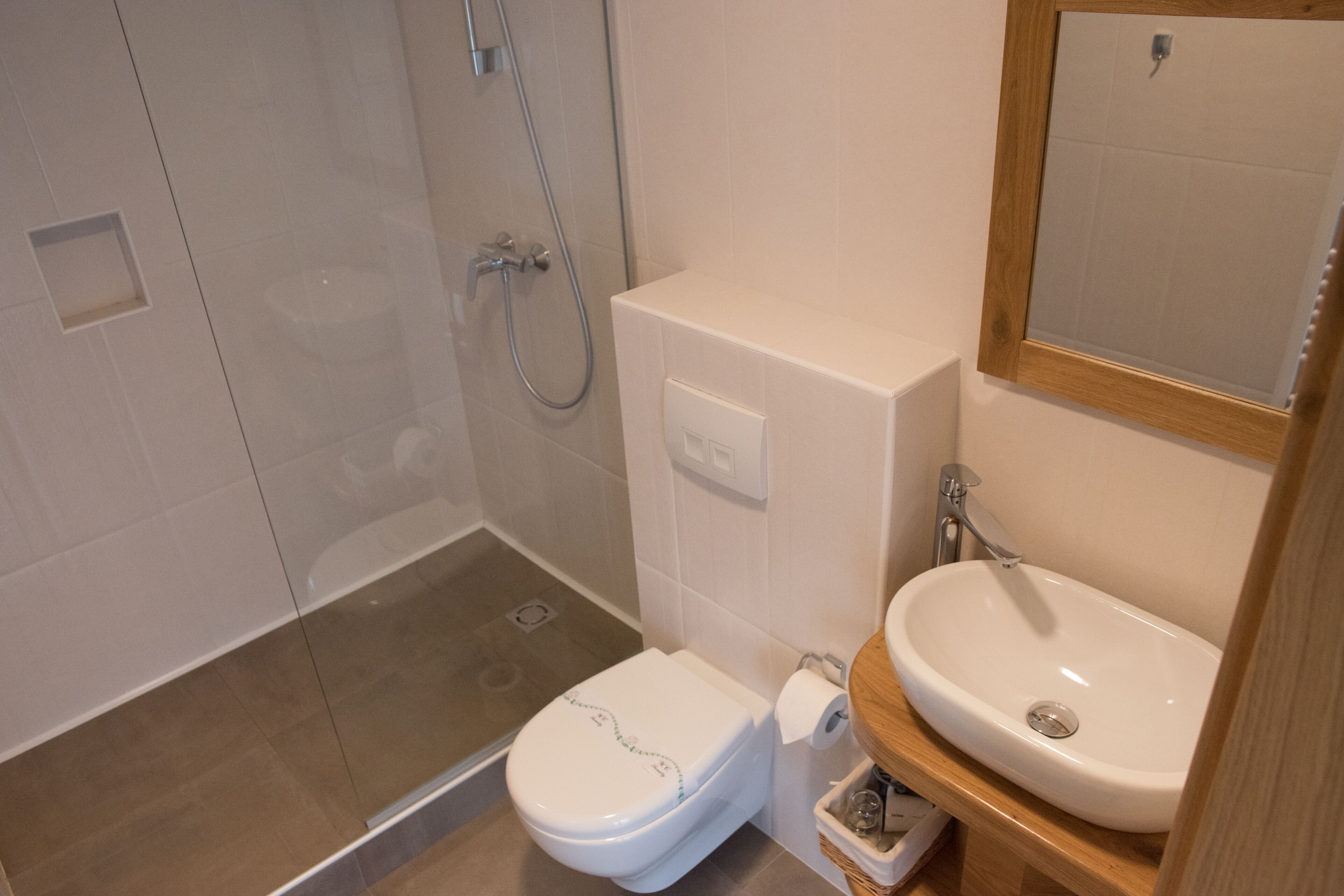 A bathroom with a toilet, shower, and sink.