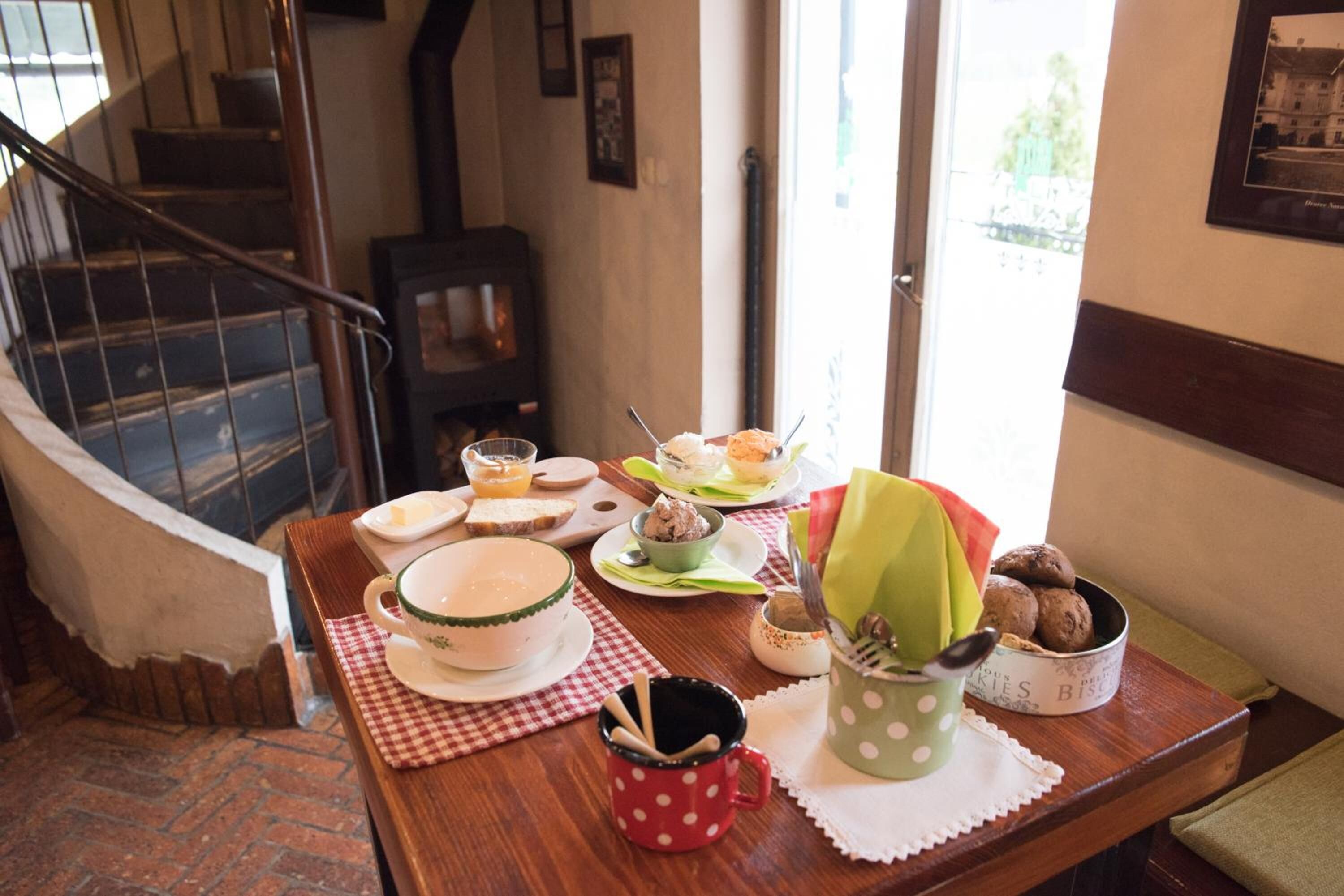 Una mesa de comedor con diversos platos y utensilios, un mantel a cuadros y una escalera al fondo.
