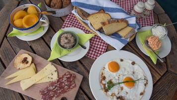 Una mesa de madera con diversos alimentos, como pan, queso, huevos y salsas.