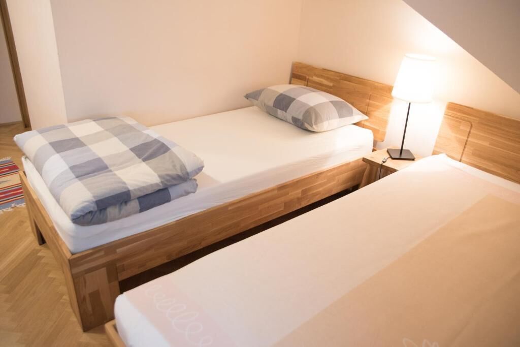 A single bed with a wooden headboard and a bedside lamp.