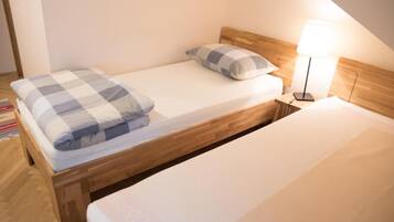 A single bed with a wooden headboard and a bedside lamp.