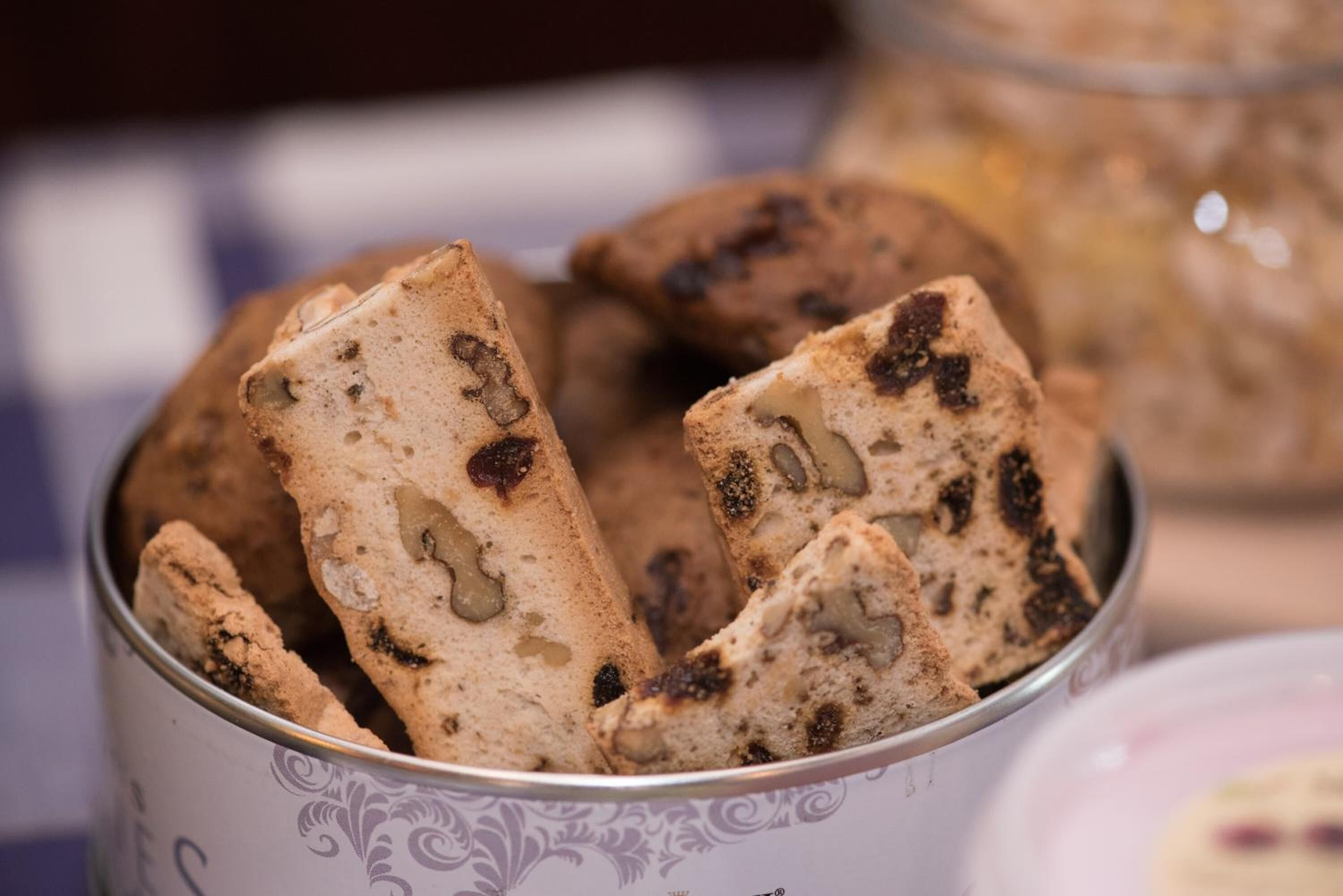 Un bote de biscotti con nueces y frutas secas visibles.