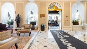 Un vestíbulo de hotel con alfombra negra que dice "CLUB WINDHAM", una estatua y vistas a la calle.