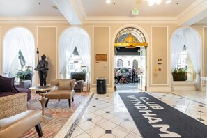 Un vestíbulo de hotel con alfombra negra que dice "CLUB WINDHAM", una estatua y vistas a la calle.